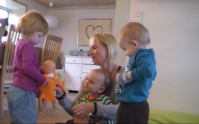 Dagplejer fra Kolding Kommune sidder sammen med tre dagplejebørn.